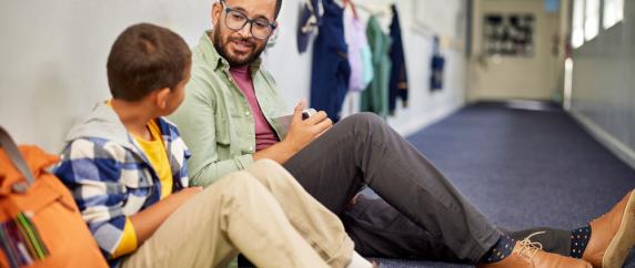 Teacher sitting on floor with child