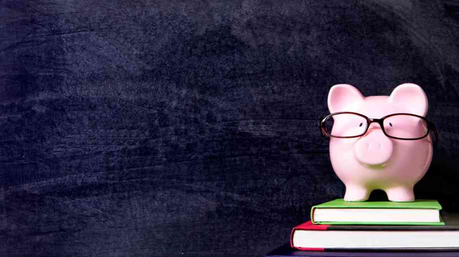 Piggy bank on top of school books.