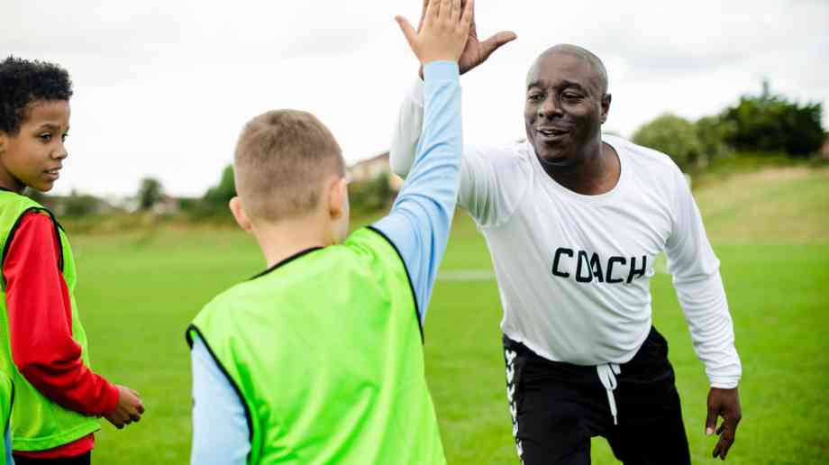 PE teacher high fives students