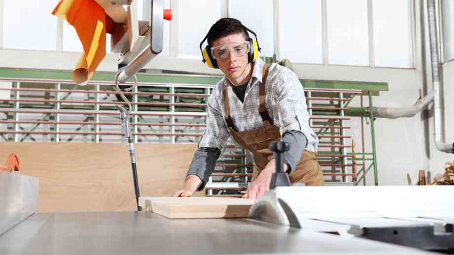 Young apprentice carpenter at work.
