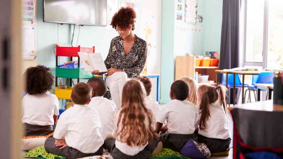 Teacher reads to children in a classroom.