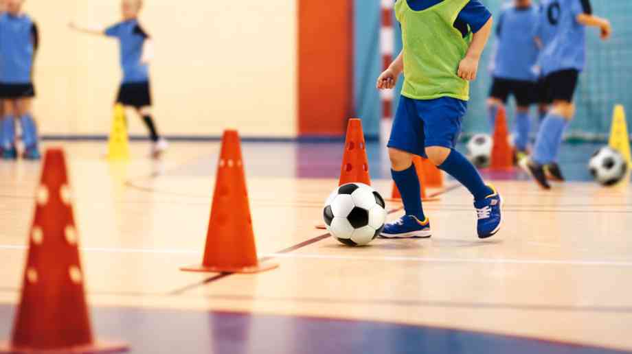 children playing football indoors